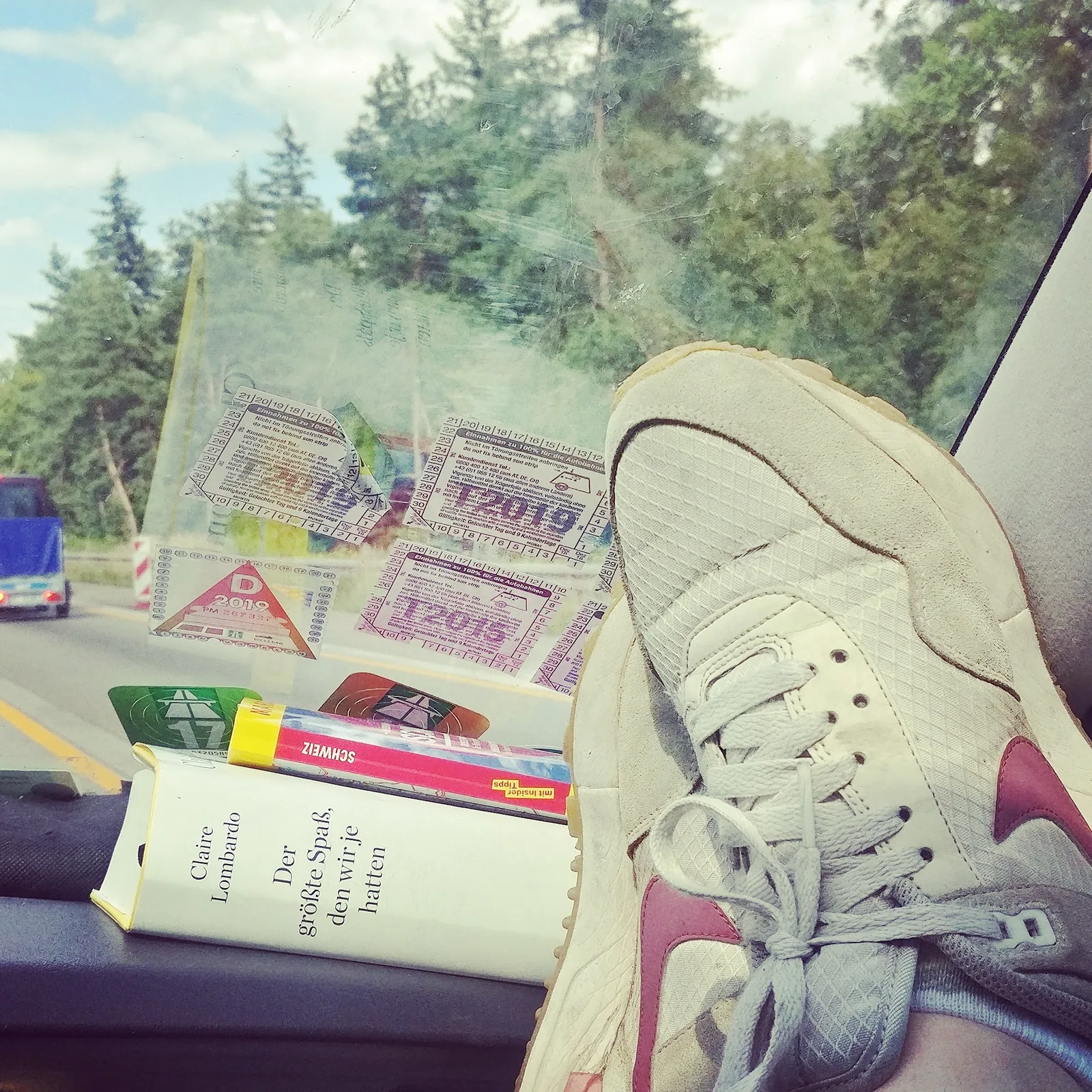 Die Füße von Anne auf dem Armaturenbrett im Auto